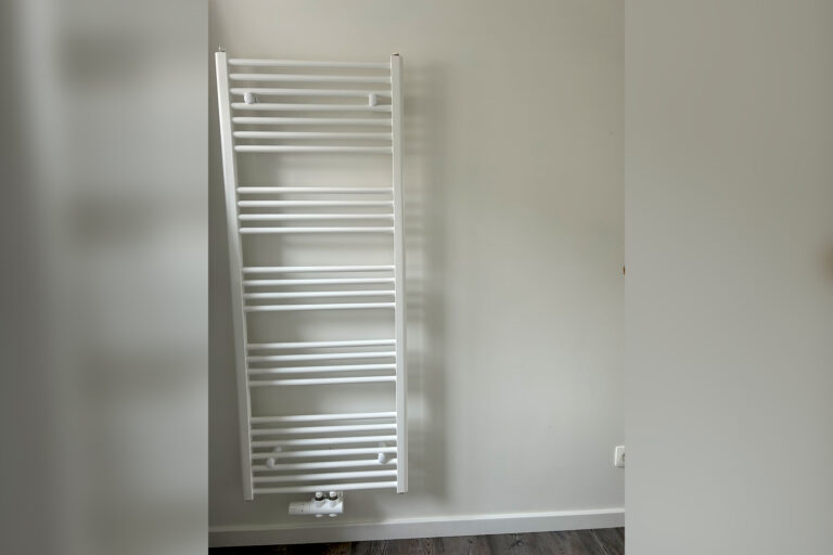 Witte moderne radiator geïnstalleerd door Degryse Projects in een badkamer