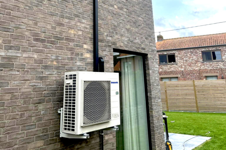 Panasonic airco unit gemonteerd aan de buitenmuur van een gebouw.